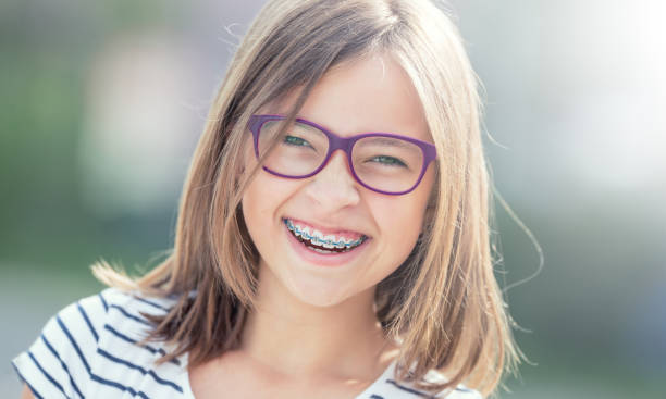 portrait of happy smiling girl with dental braces and glasses.